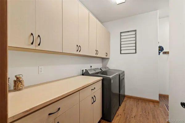 a view of a storage and utility room with wooden floor