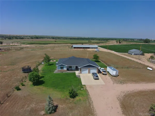 an aerial view of a house with a garden and lake view