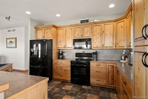 a kitchen with stainless steel appliances granite countertop a refrigerator stove and sink