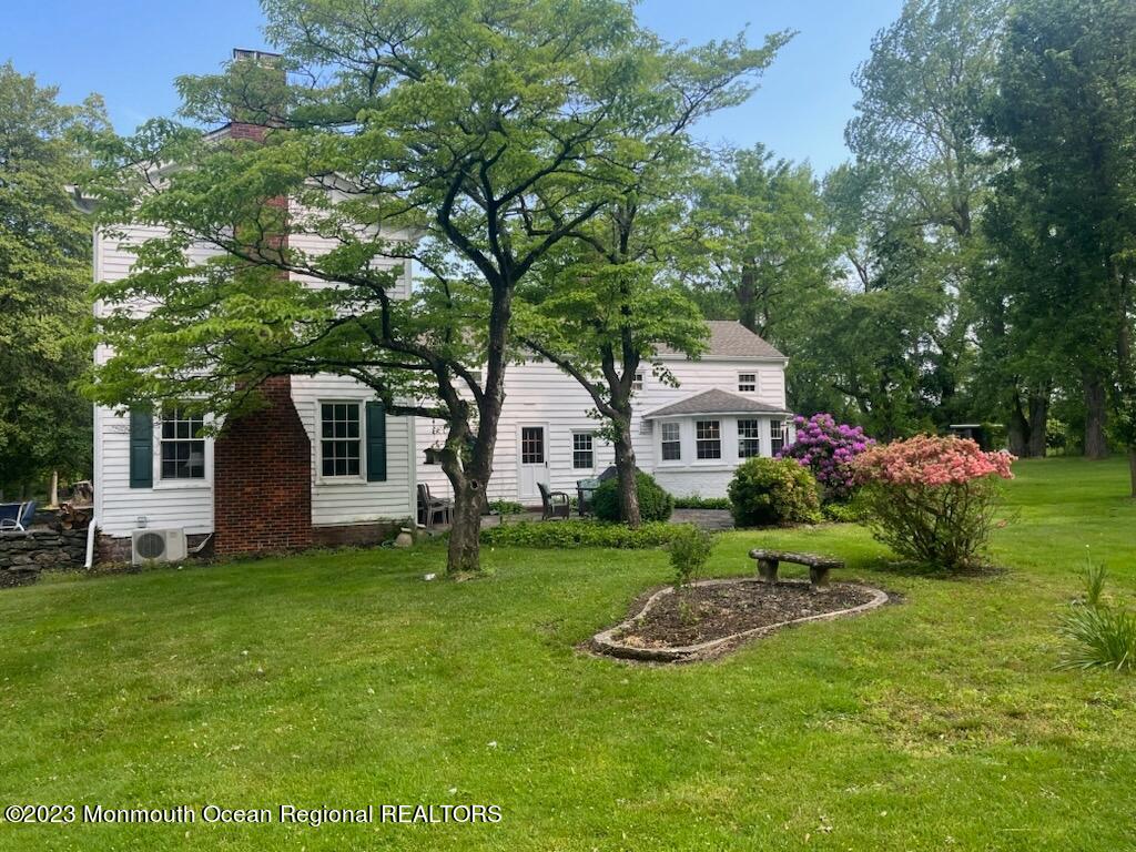 415 Pleasant Valley Road Morganville, NJ 07751 - Photo 12 of 16 a front view of a house with a garden and trees