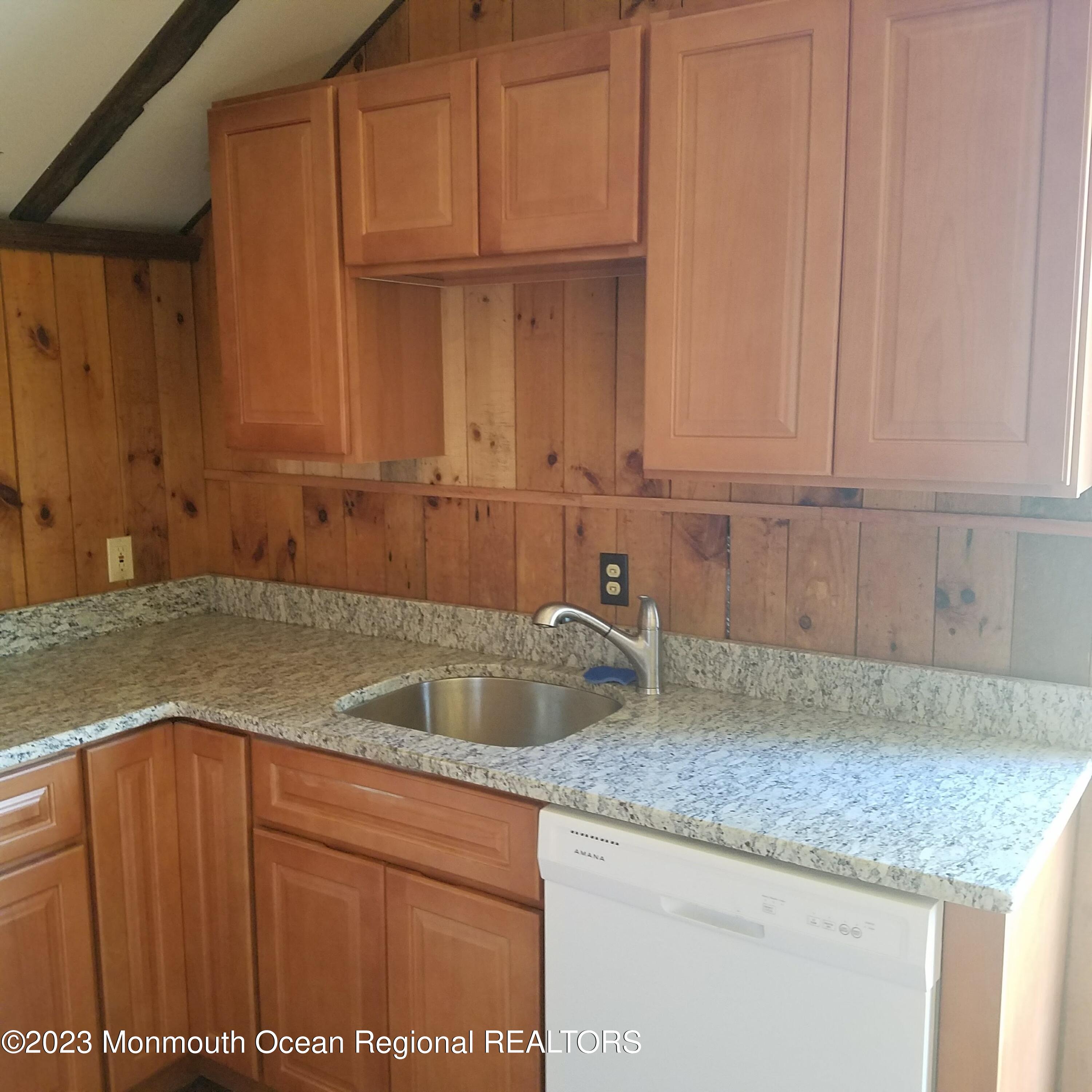 415 Pleasant Valley Road Morganville, NJ 07751 - Photo 15 of 16 a kitchen with granite countertop a sink dishwasher refrigerator and cabinets