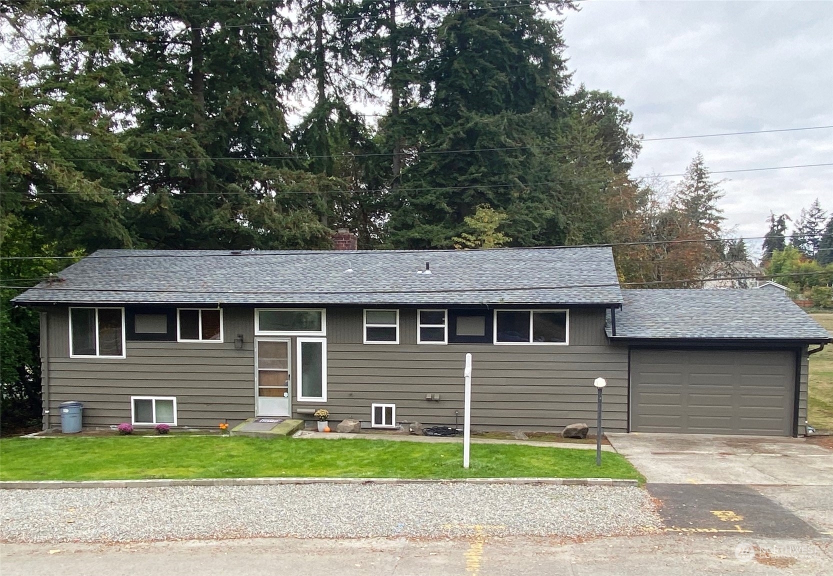 a front view of a house with a garden and plants