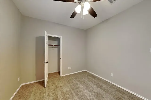 an empty room with chandelier fan