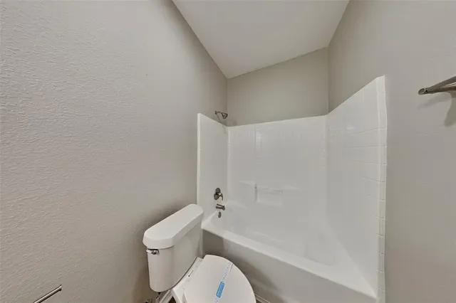 a white toilet sitting next to a bath tub
