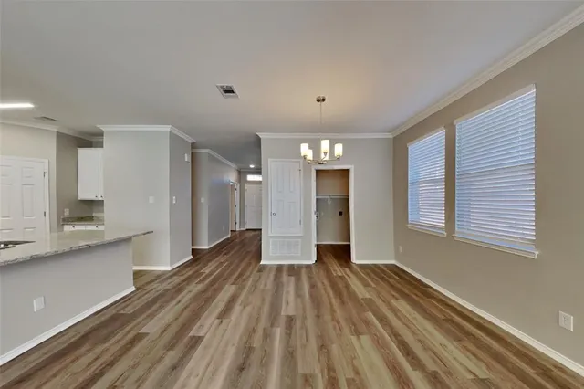 a view of a big room with wooden floor and windows