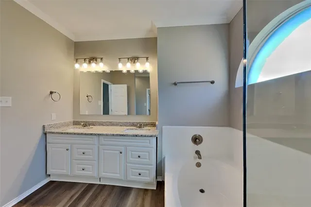 a spacious bathroom with a granite countertop sink a mirror and a shower