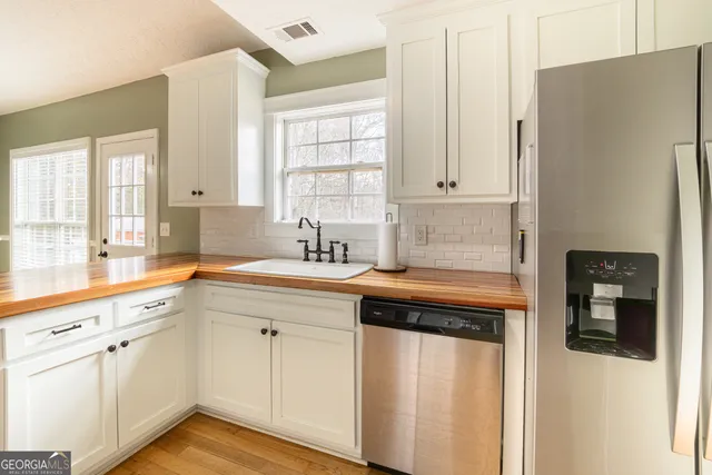 a kitchen with white cabinets and white appliances