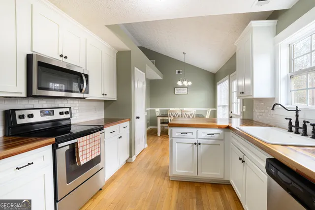 a kitchen with stainless steel appliances granite countertop a sink and stove top oven