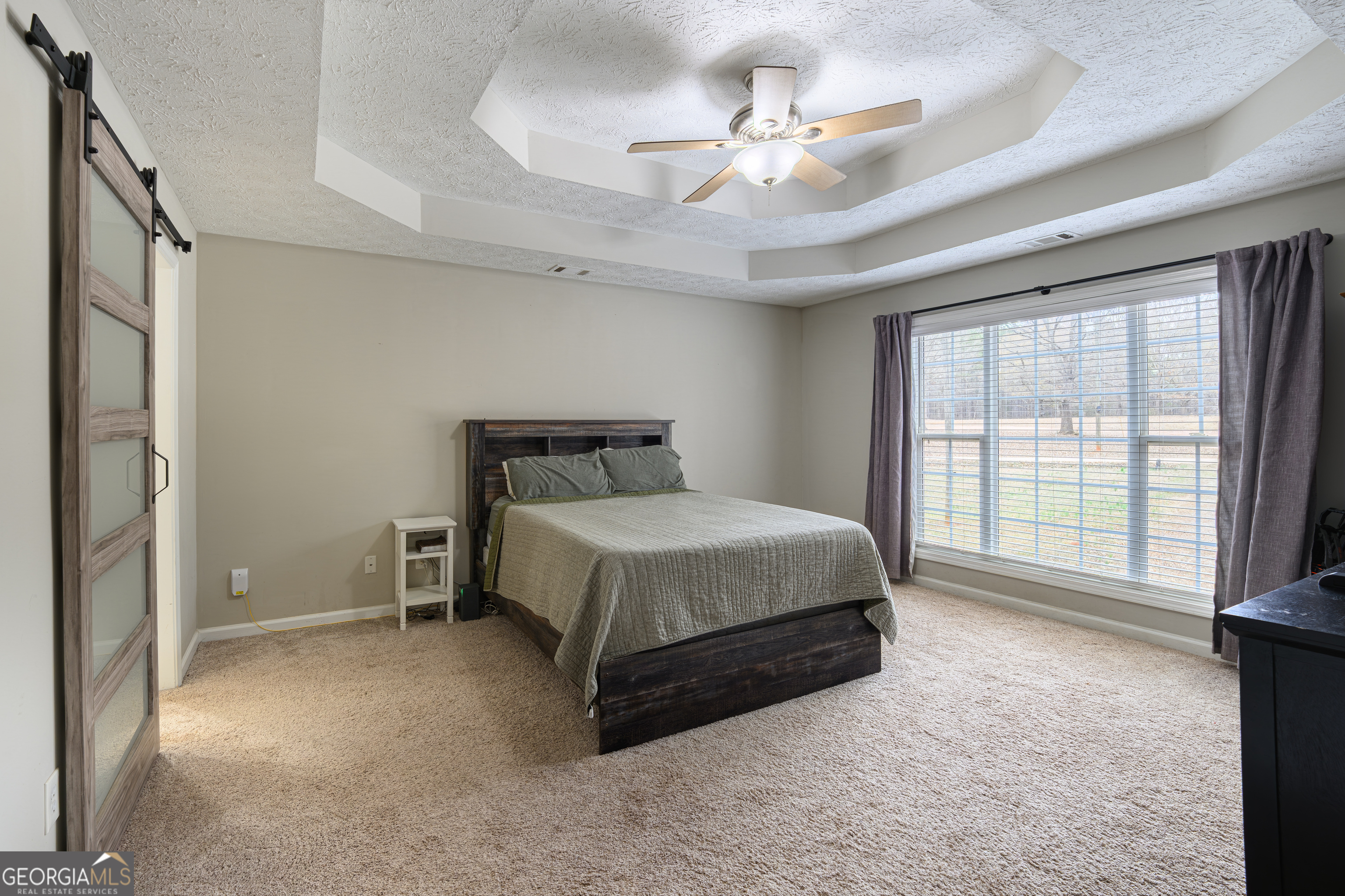 171 Hunter Road Griffin, GA 30224 - Photo 24 of 31 a spacious bedroom with a bed a chandelier and a large window