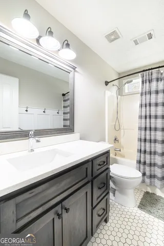 a bathroom with a sink a toilet a mirror and shower
