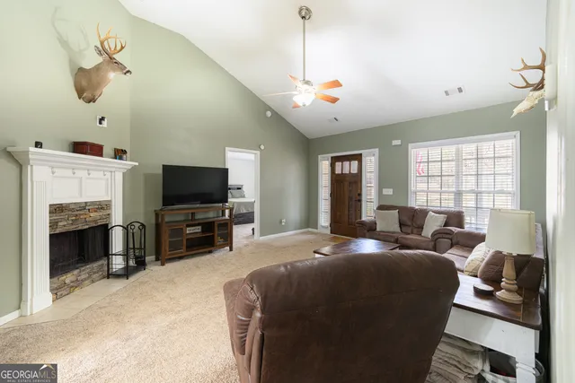 a living room with furniture a fireplace and a flat screen tv