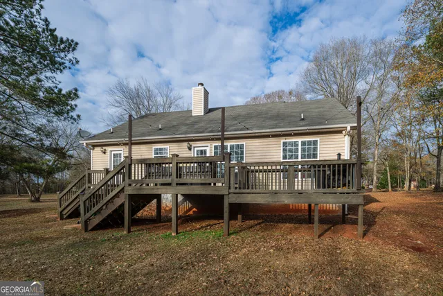 a view of a house with a yard and deck in a backyard
