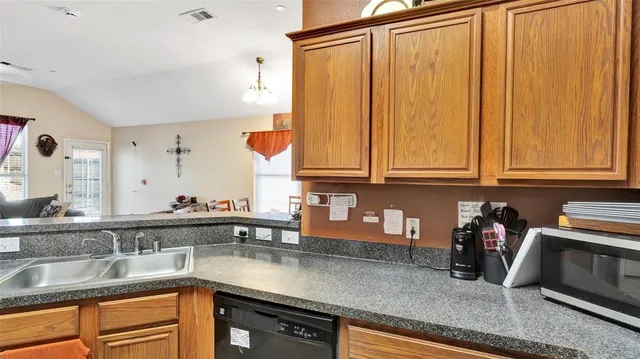 a kitchen with stainless steel appliances granite countertop a sink a stove and a wooden cabinets