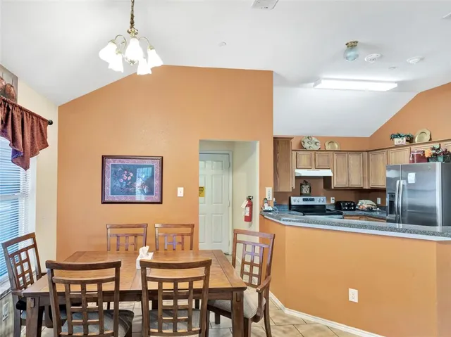a living room with furniture a flat screen tv and kitchen view