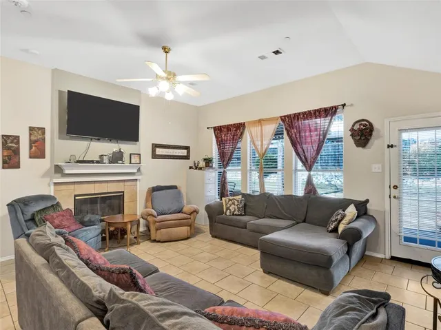 a living room with furniture a flat screen tv and a fireplace