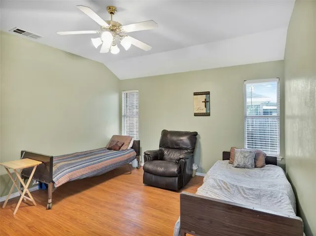 a kitchen with stainless steel appliances granite countertop a refrigerator a stove and a dining table with wooden floor