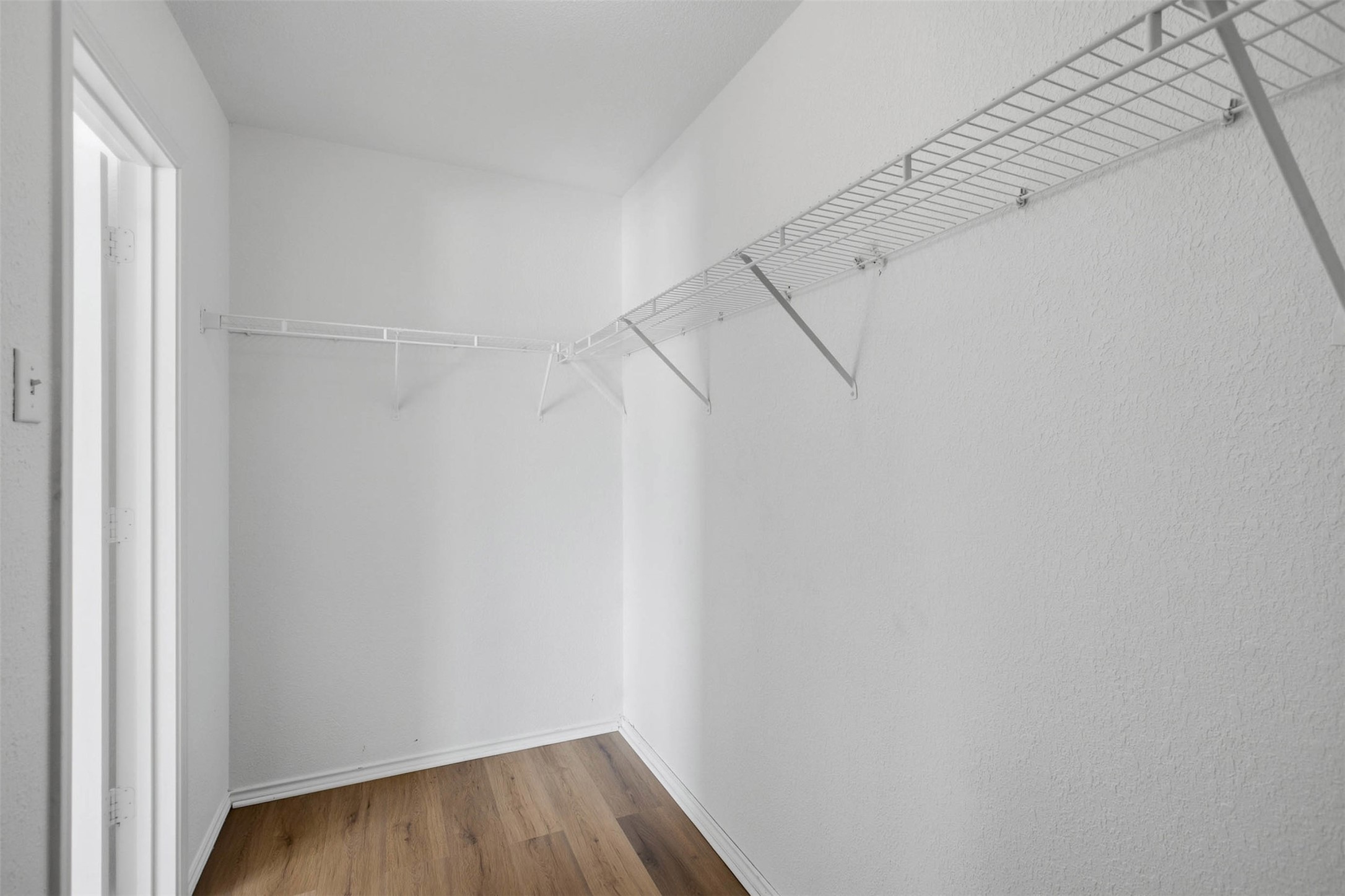 13808 Harris Ridge Boulevard, Unit B Pflugerville, TX 78660 - Photo 24 of 33 Ample wire shelving lines this functional closet space featuring durable wood-look flooring.