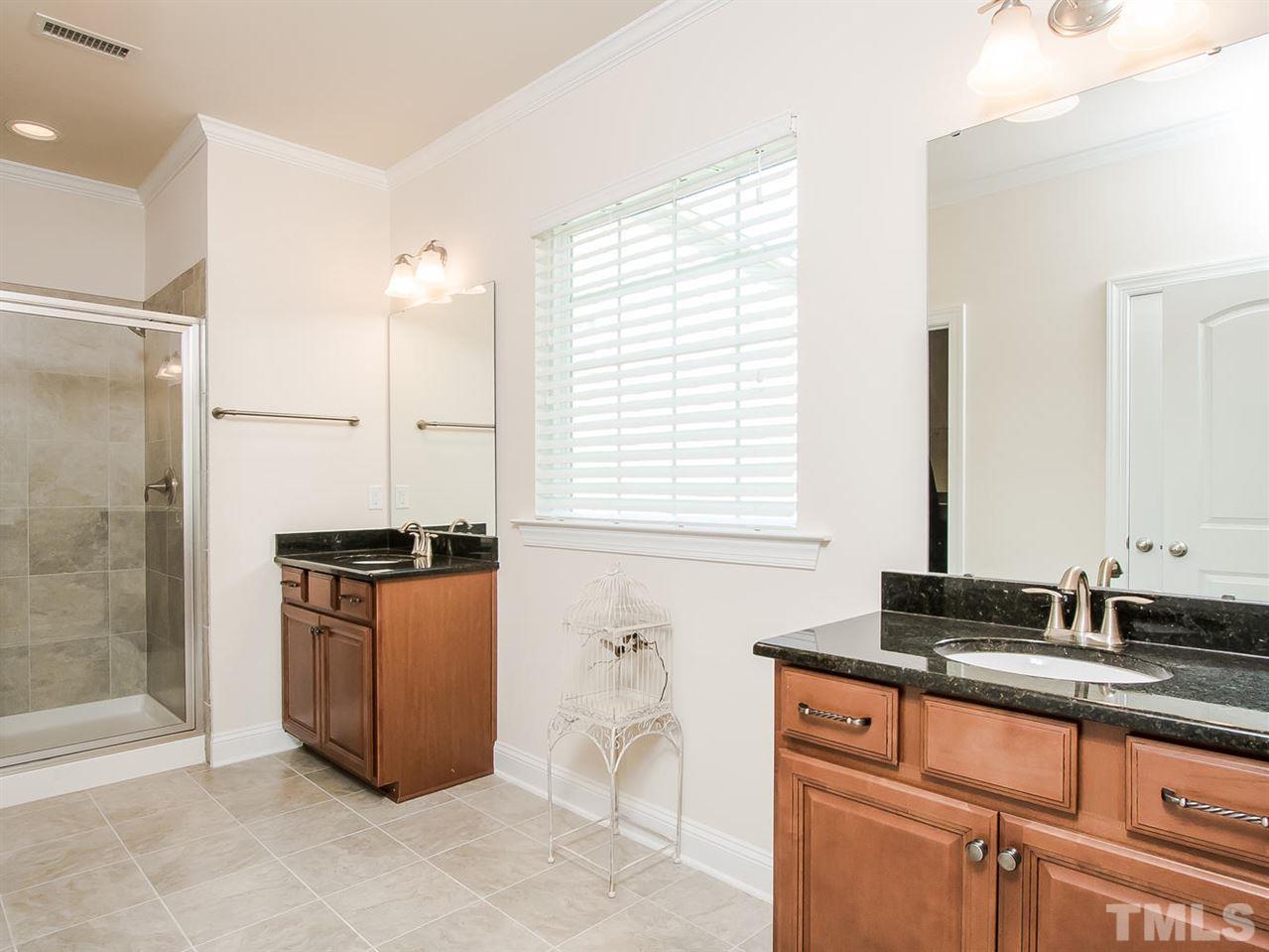 6508 Ridgemount Street Wake Forest, NC 27587 - Photo 4 of 24 Step into your new spa bath at 6508 Ridgemount. Tile floors, large window, double vanity, large walk-in tiled shower are wonderful amenities to have when trying to get ready for an outing. There is also a separate toilet room and separate linen closet.