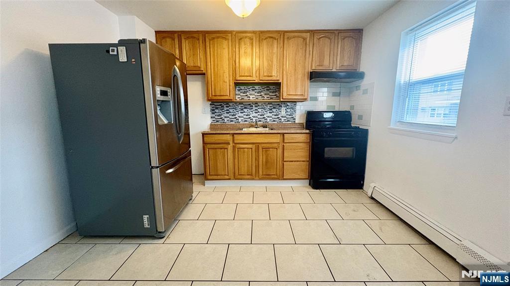 299 Main Street, Unit 7 Lodi, NJ 07644 - Photo 7 of 14 a kitchen with stainless steel appliances granite countertop a refrigerator a stove a sink and a window