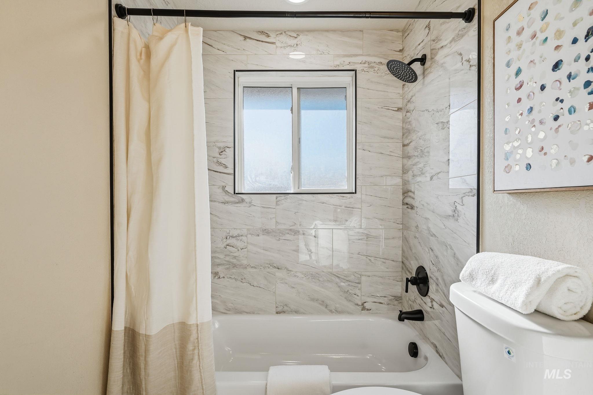 1990 Panama Street Boise, ID 83705 - Photo 39 of 50 Bathtub with subway tile surround, black plumbing fixtures, and a framed window