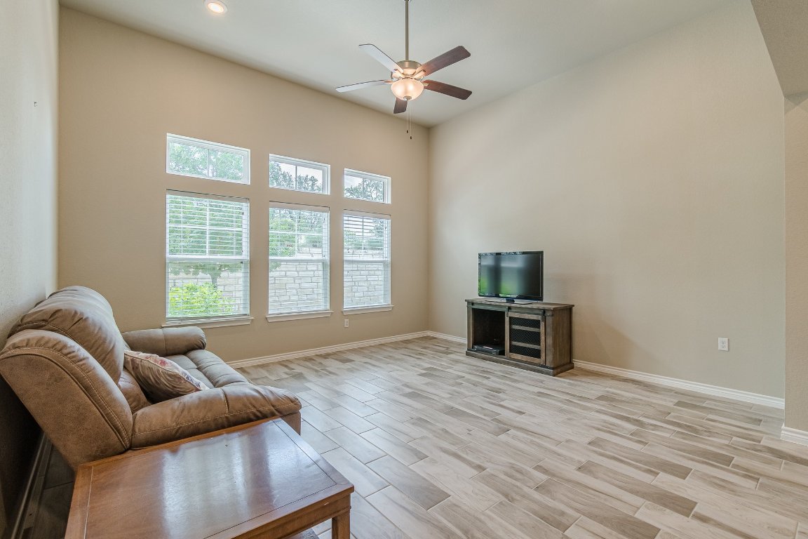 1330 Wonder World Drive, Unit 102 San Marcos, TX 78666 - Photo 11 of 27 a living room with furniture a flat screen tv and a window