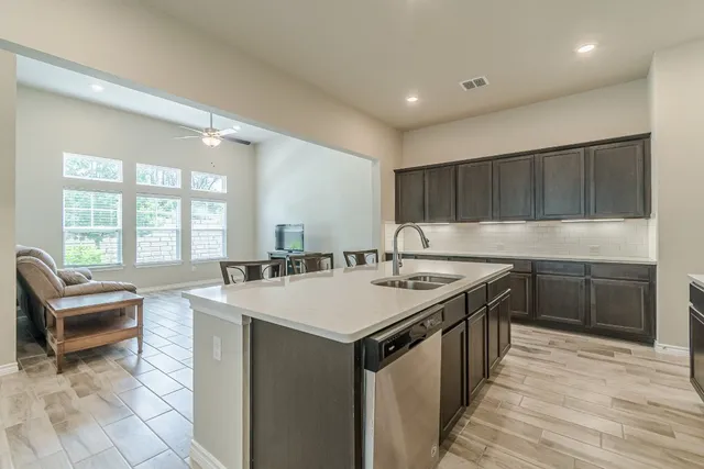 a kitchen with granite countertop a sink and a stove top oven with wooden floor