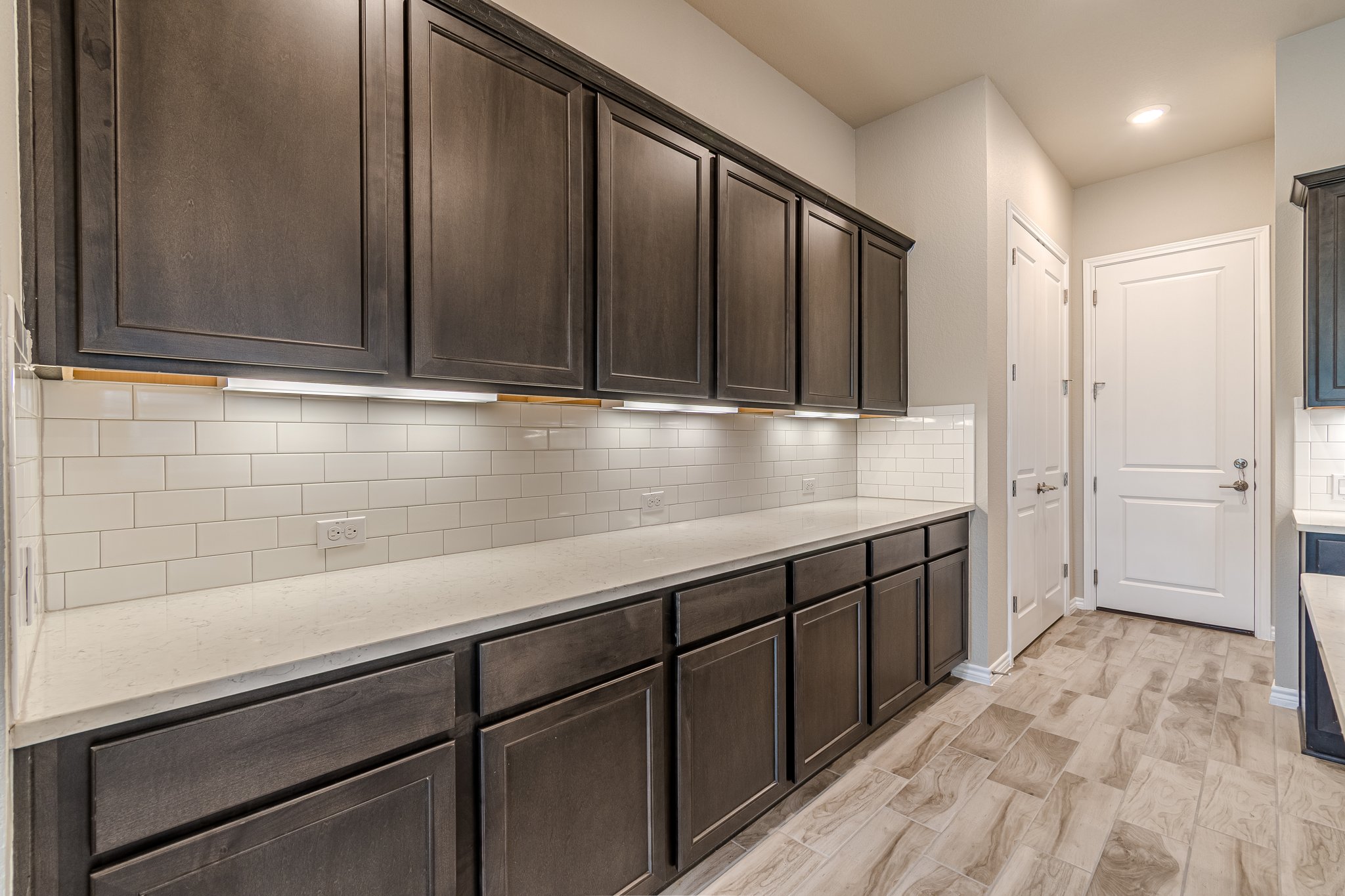 108 Lafitte Drive, Unit 102 San Marcos, TX 78666 - Photo 16 of 27 Kitchen featuring dark brown cabinetry, decorative backsplash, light stone countertops, and recessed lighting