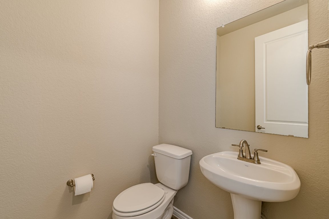 1330 Wonder World Drive, Unit 102 San Marcos, TX 78666 - Photo 17 of 27 a bathroom with a sink a toilet and mirror
