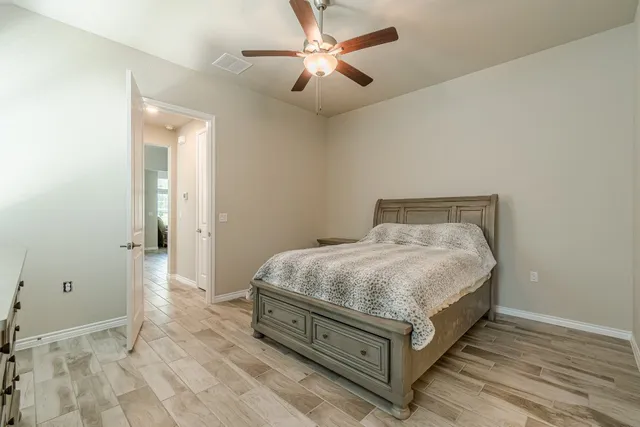a bedroom with a bed and a ceiling fan