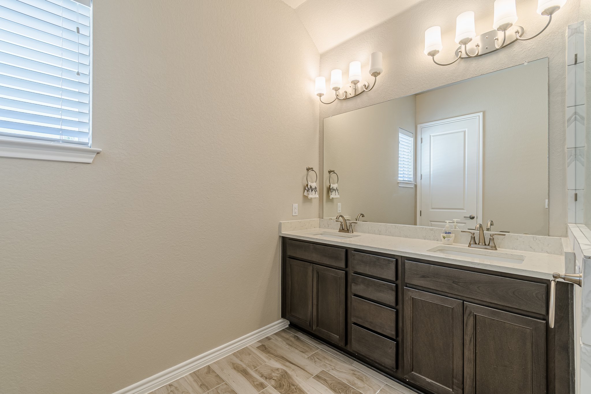 108 Lafitte Drive, Unit 102 San Marcos, TX 78666 - Photo 22 of 27 Full bath with double vanity and wood finished floors