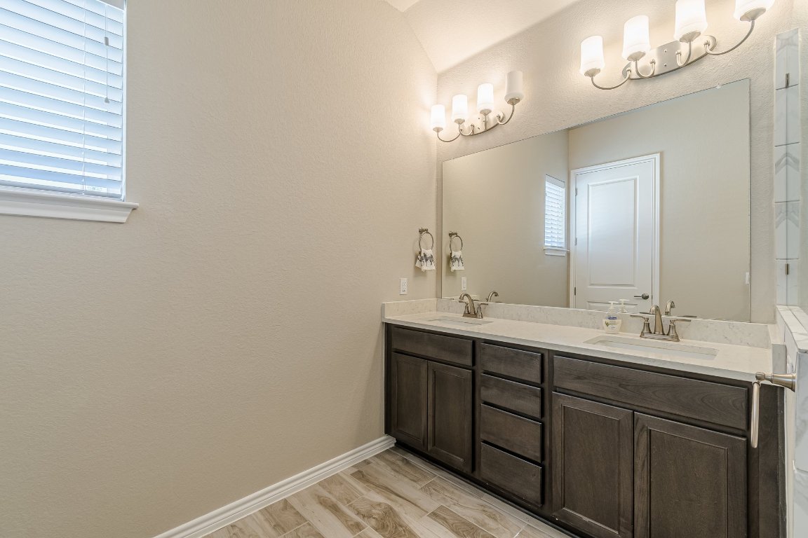 1330 Wonder World Drive, Unit 102 San Marcos, TX 78666 - Photo 22 of 27 a bathroom with a double vanity sink and a mirror