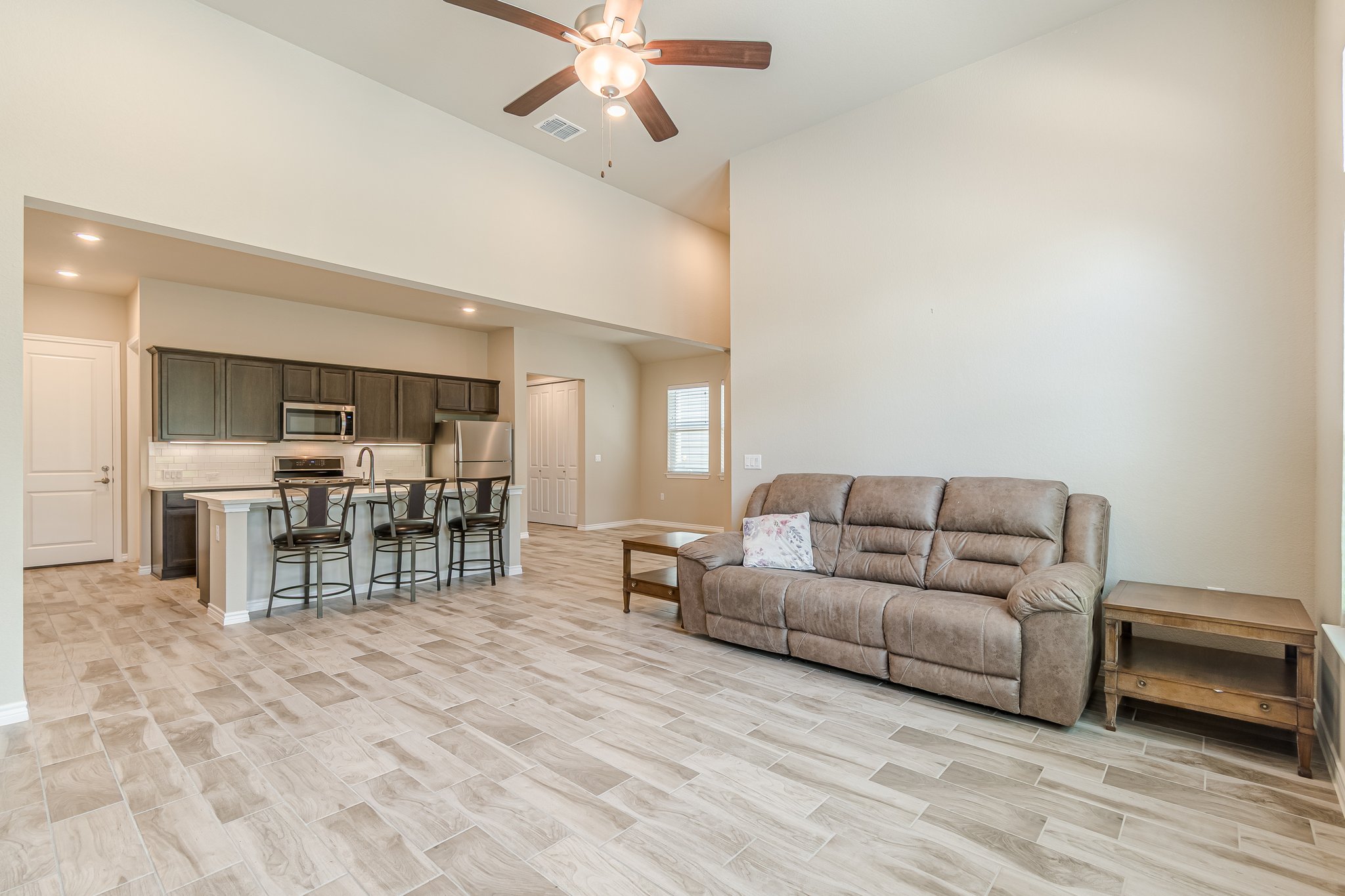 108 Lafitte Drive, Unit 102 San Marcos, TX 78666 - Photo 8 of 27 Living area featuring a ceiling fan, a towering ceiling, and recessed lighting