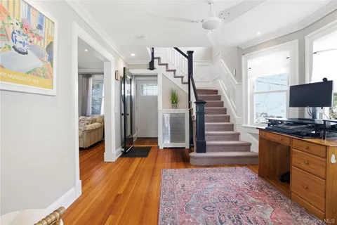 a view of a hallway with wooden floor and staircase