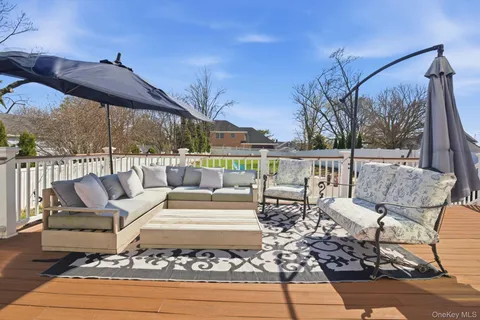 a view of a patio with couches chairs dining table and chairs with wooden floor