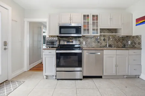 a kitchen with white cabinets and stainless steel appliances