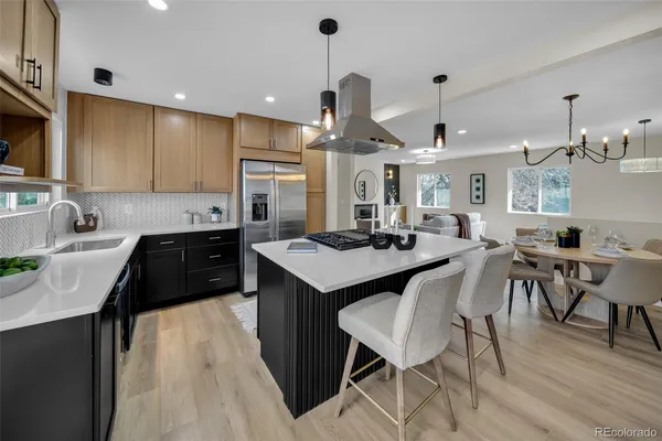 a kitchen with a dining table chairs sink and cabinets