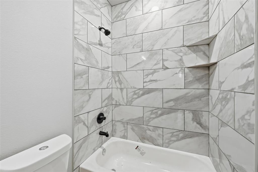 308 Lewis Street Cleburne, TX 76031 - Photo 11 of 20 a bathroom with a bathtub and shower