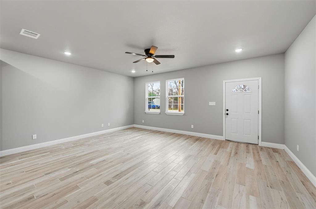 308 Lewis Street Cleburne, TX 76031 - Photo 2 of 20 wooden floor in an empty room with a window