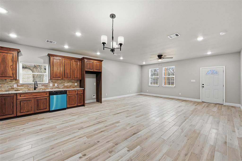 308 Lewis Street Cleburne, TX 76031 - Photo 4 of 20 a large kitchen with stainless steel appliances granite countertop a large counter top and wooden floors