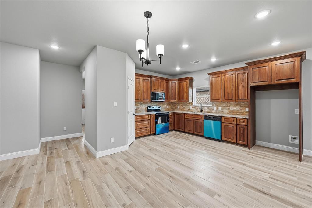 308 Lewis Street Cleburne, TX 76031 - Photo 5 of 20 a kitchen with stainless steel appliances granite countertop a refrigerator a sink dishwasher a stove and a wooden cabinets