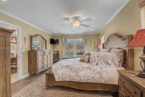 a bedroom with a large bed a flat tv screen and dresser