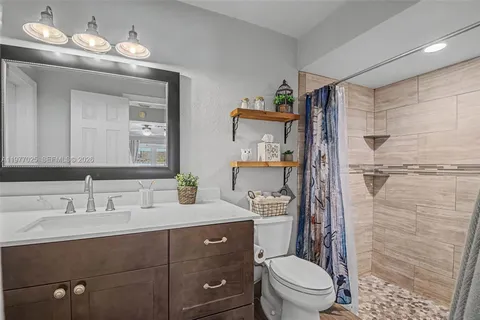 a bathroom with a toilet a sink a shower and mirror