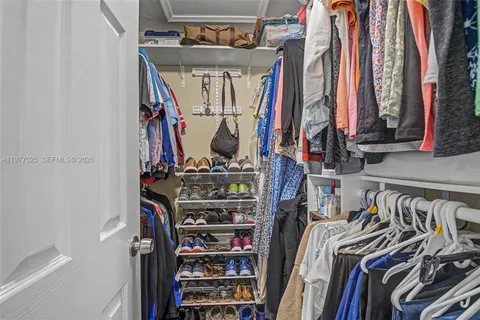 a view of walk in closet with clothes