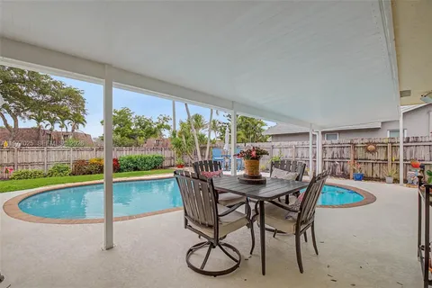 a dining room with furniture and a floor to ceiling window