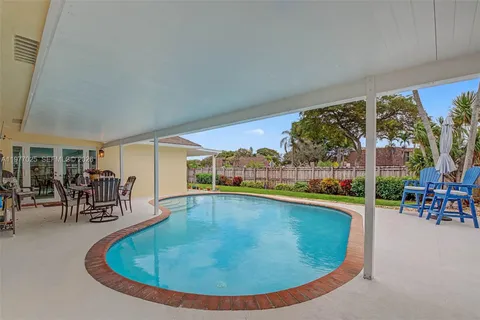 an outdoor space with swimming pool and furniture