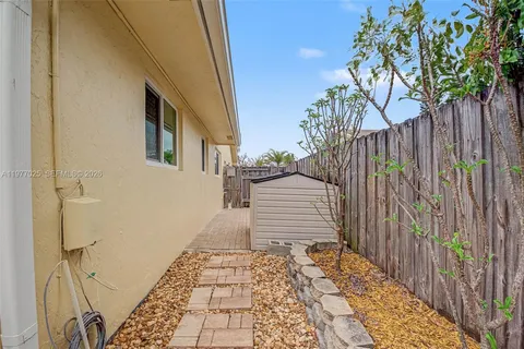 a view of a pathway of a house with wooden fence