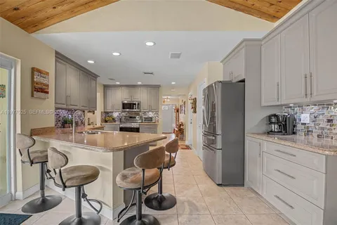 a kitchen with stainless steel appliances granite countertop a refrigerator and a stove top oven