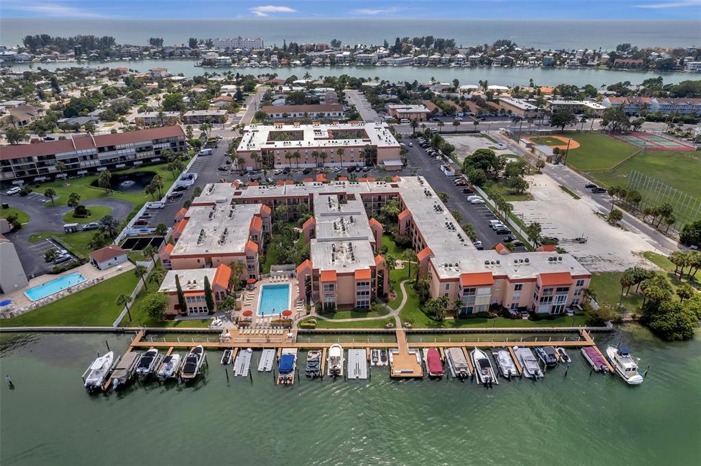 8911 Blind Pass Road, Unit 118 St. Pete Beach, FL 33706 - Photo 1 of 1 an aerial view of multiple houses with swimming pool