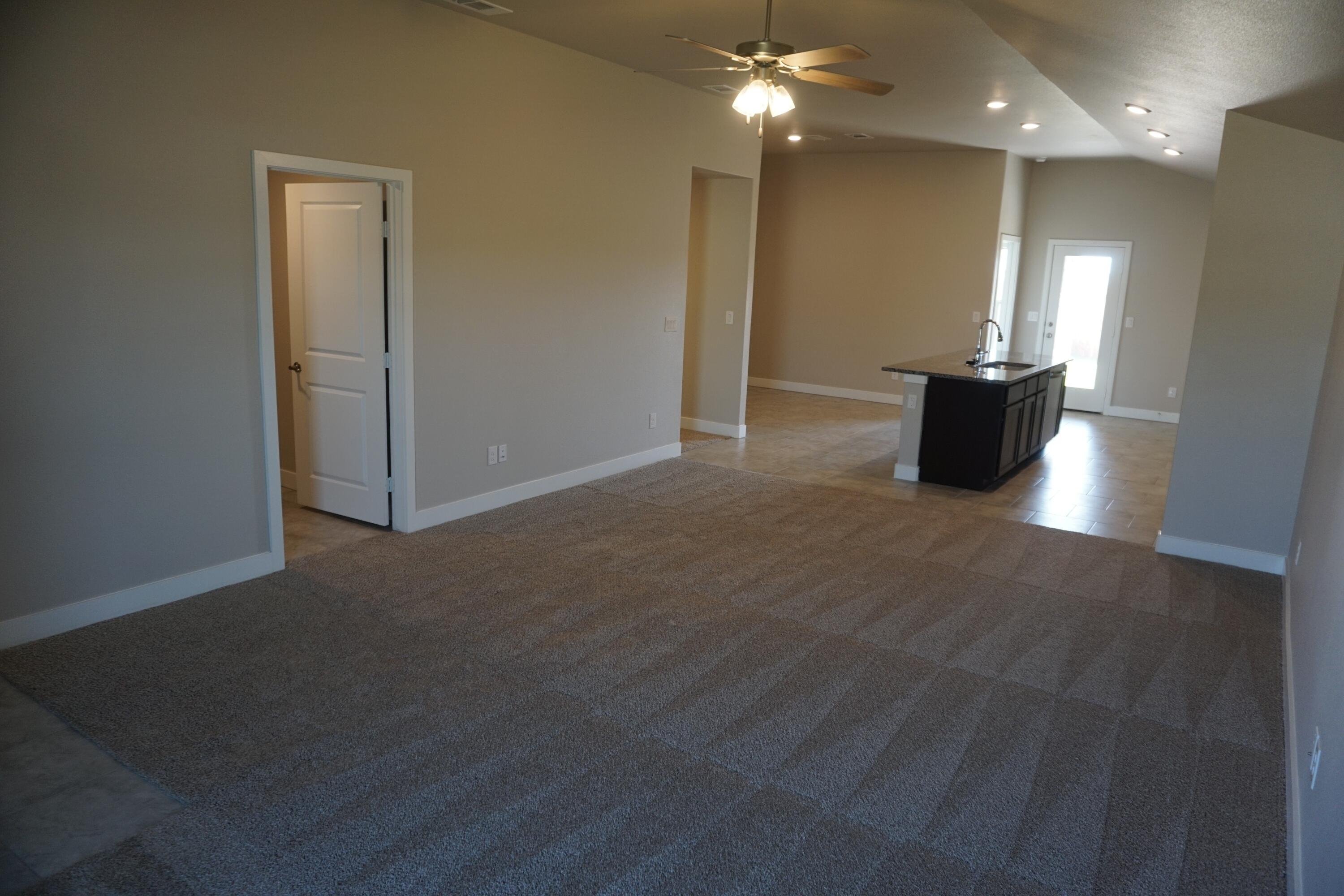 7517 31st Street Lubbock, TX 79407 - Photo 2 of 14 a view of a livingroom with a kitchen counter space and a fireplace