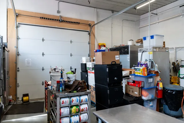 a kitchen with stainless steel appliances granite countertop a stove a sink and a refrigerator with wooden cabinets